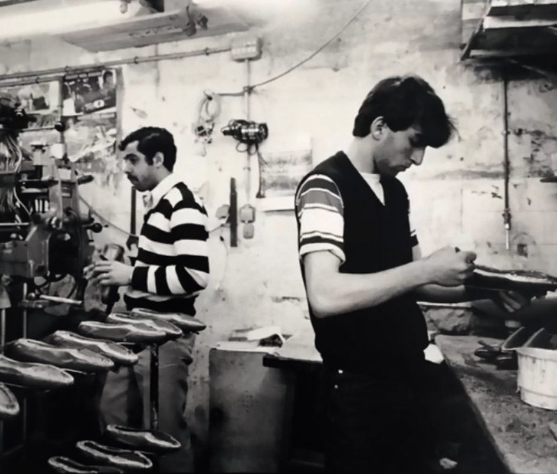Photo d'archive en noir et blanc montrant Eric Semerdjian jeune travaillant à la fabrication de chaussures dans l'atelier familial. Origine de la marque SMR23.